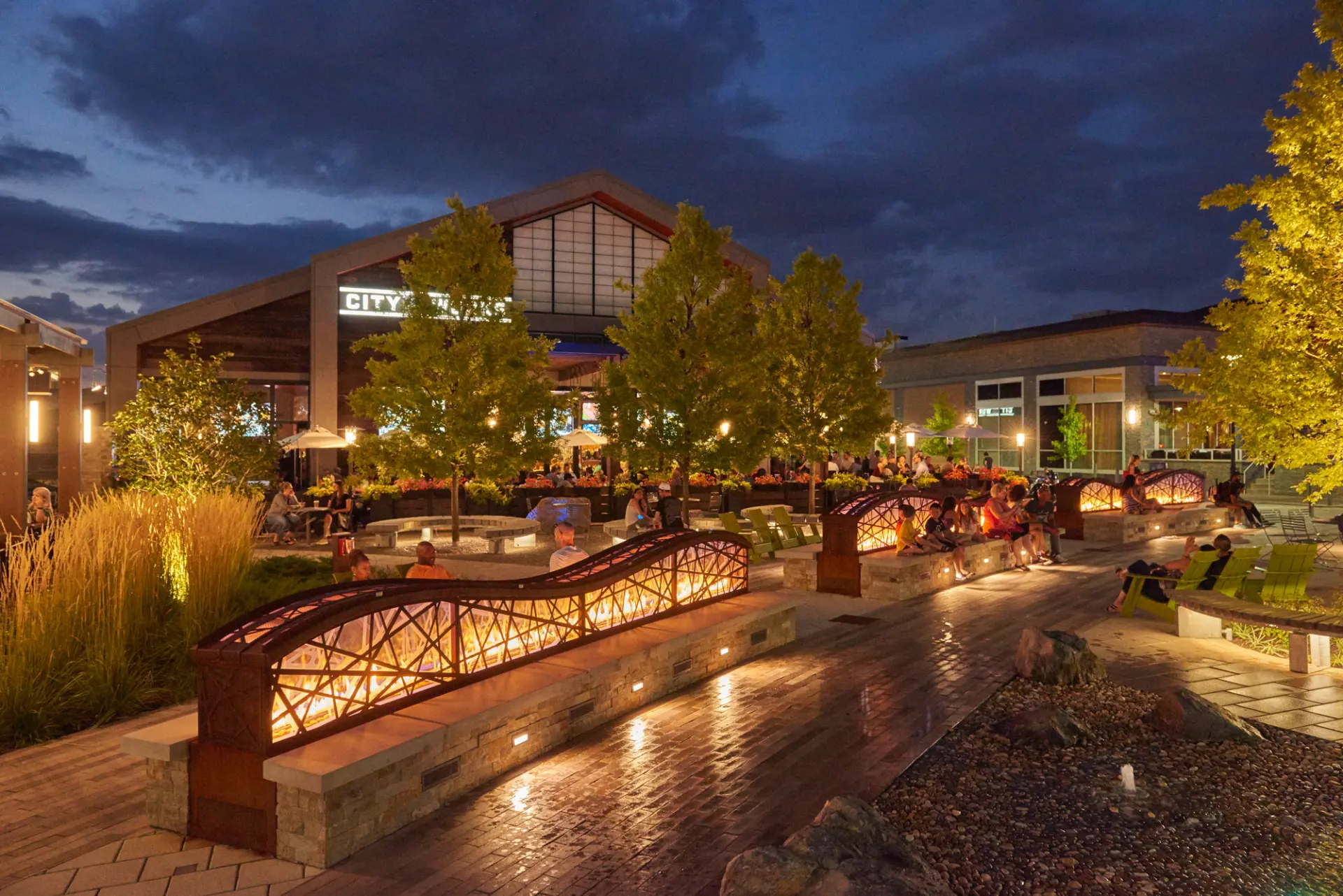 King of Prussia town center outdoor plaza with dining, fire pits and evening lighting
