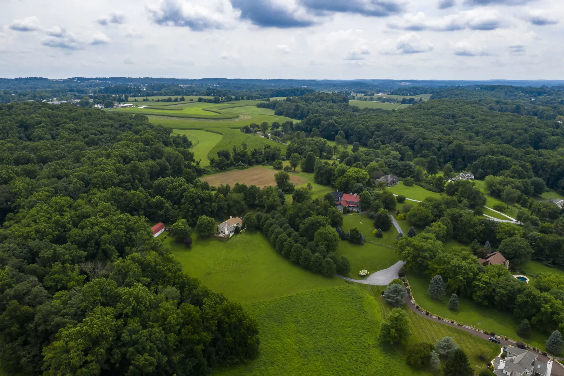 Aerial view of Chester Springs, Pennsylvania with rolling green hills, farmland and wooded estates